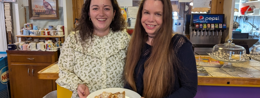 Clemence Nayral and Christine Fauver hold a plate of french toast in the goochland restaurant made from imported french bread