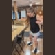 woman moping a restaurant floor with rags on her feet while laughing